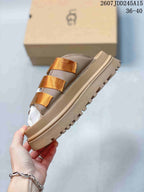 Side view of the tan sandal showing the platform sole, lug tread, and three metallic-gold straps.