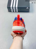 Rear view showing the orange heel, red pull tab, white midsole and coral outsole.
