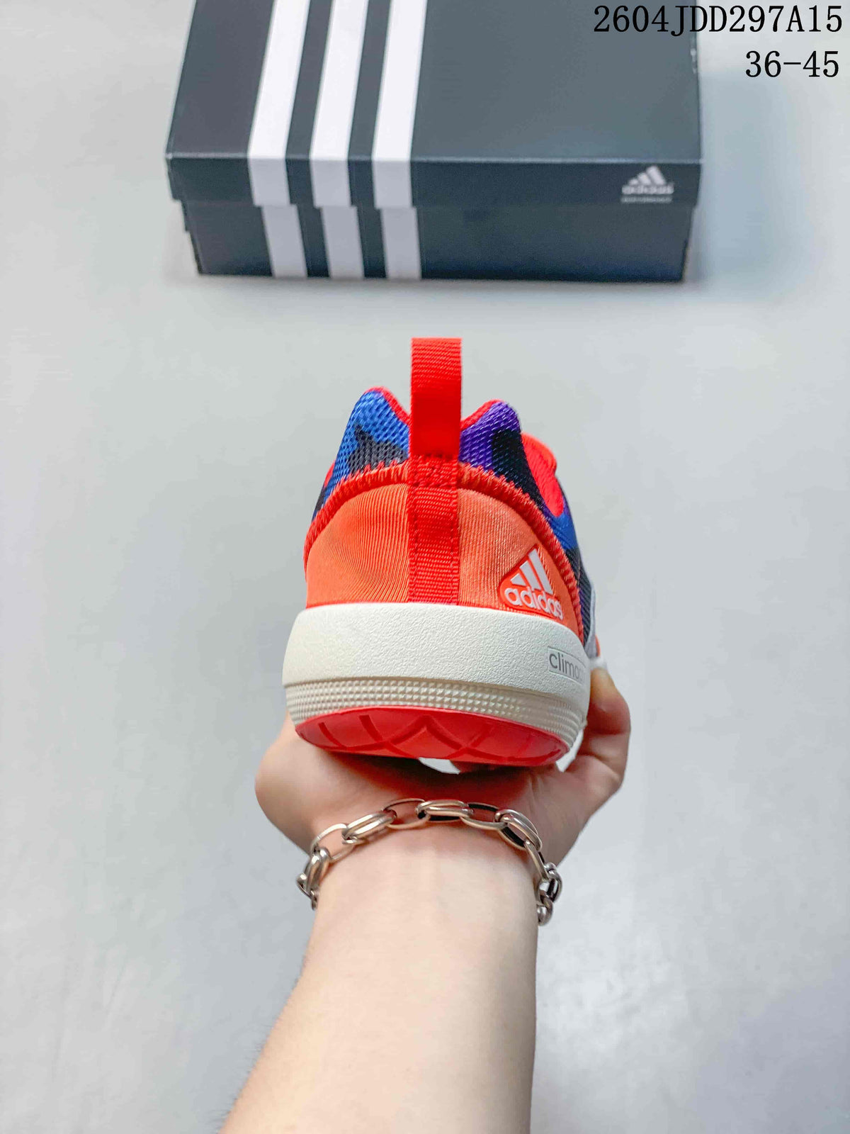 Rear view showing the orange heel, red pull tab, white midsole and coral outsole.