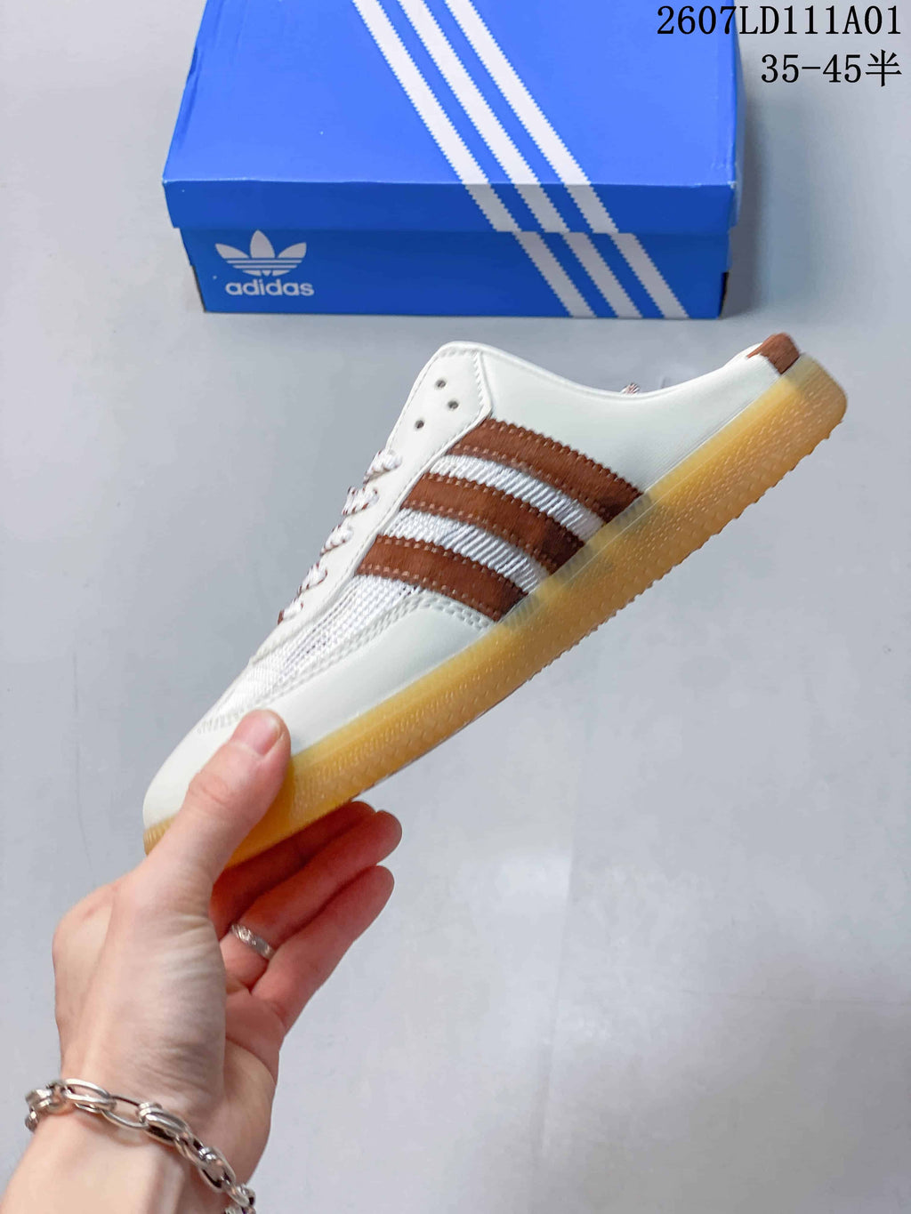 Side profile of the low-profile mule sneaker with brown stripes and gum-colored sole