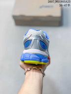 Rear view of the sneaker showing the blue heel collar, silver panels, and layered outsole.