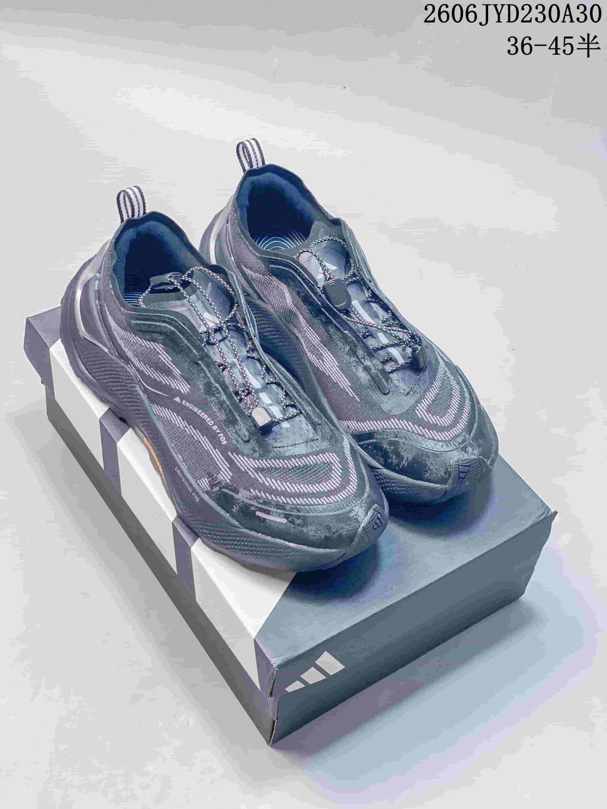 Pair of gray Adidas Holo Peak trail running shoes with patterned uppers and quick-lace closures