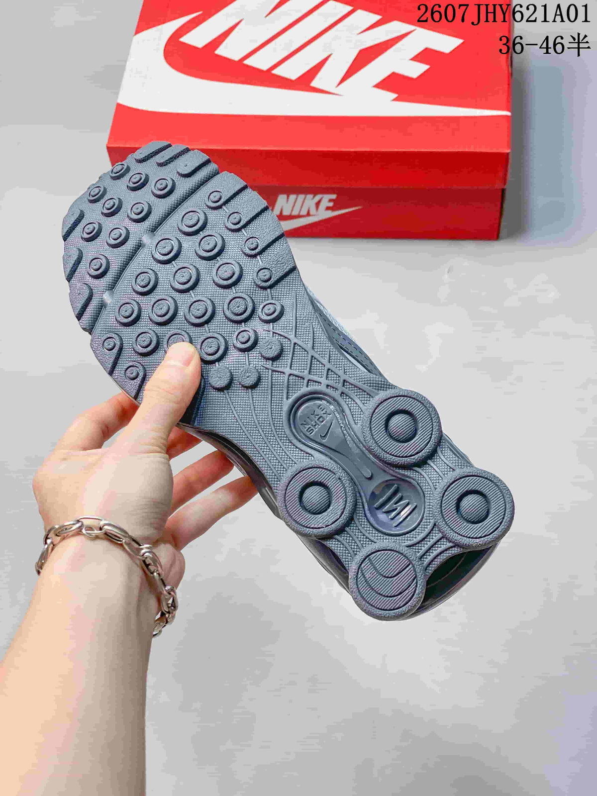 Outsole view showing the circular tread and heel columns of a silver and gray sneaker