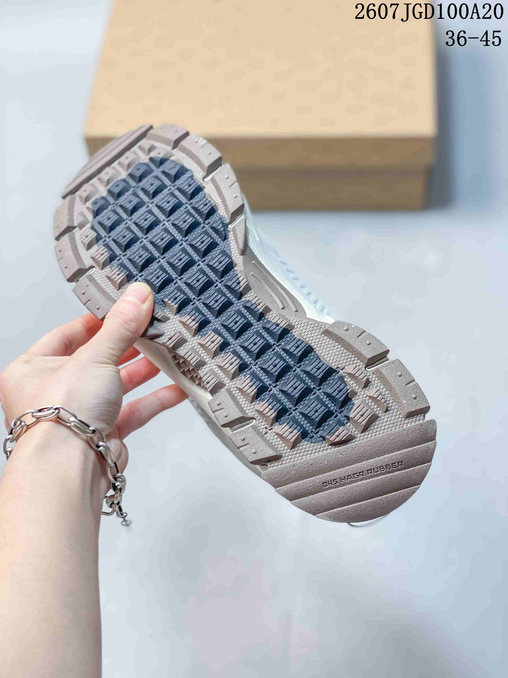 Close view of the patterned rubber outsole on a Nike Zoom Vomero Roam sneaker, with the style code and size range visible above.