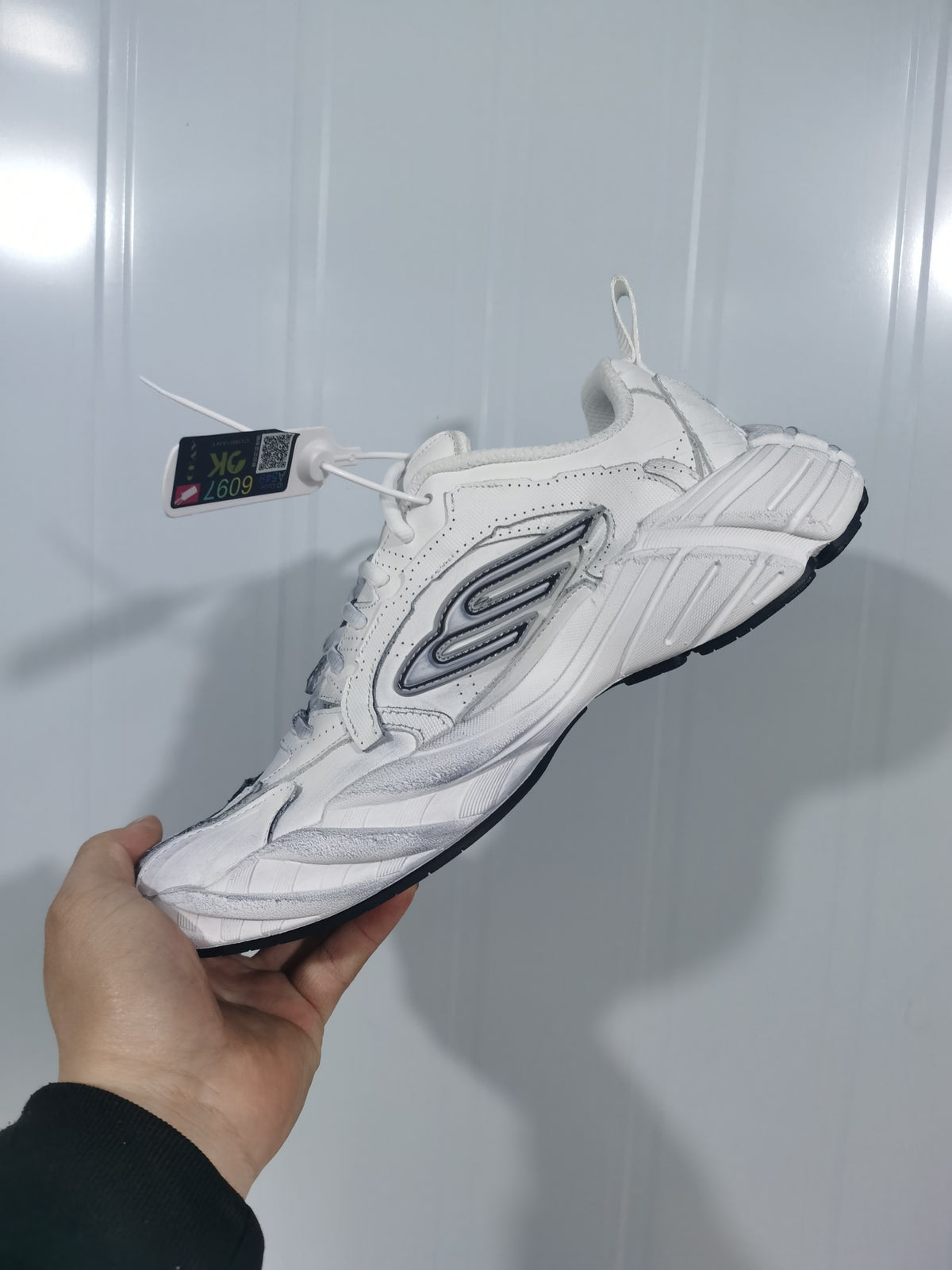 Opposite side view showing the white sneaker upper, grey accents, padded collar, and black outsole.