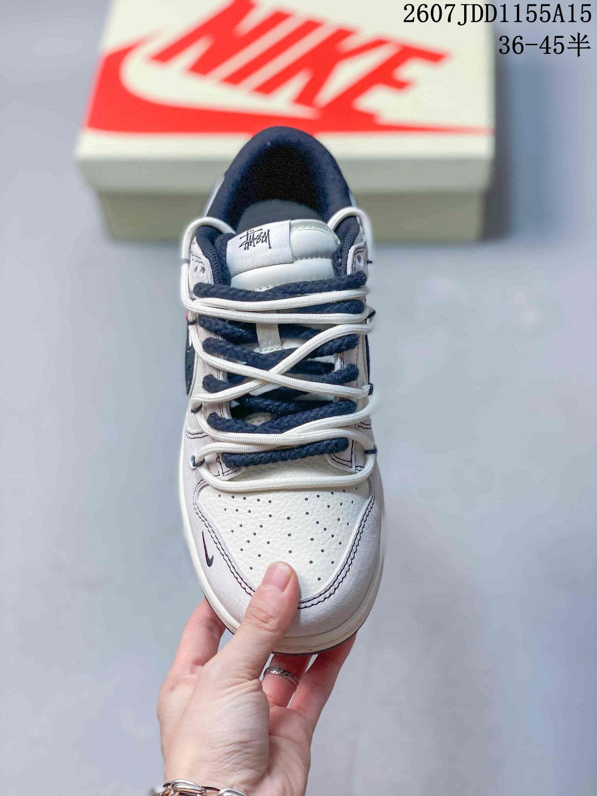 Top view showing the perforated white toe box, layered white and navy laces, and branded tongue.