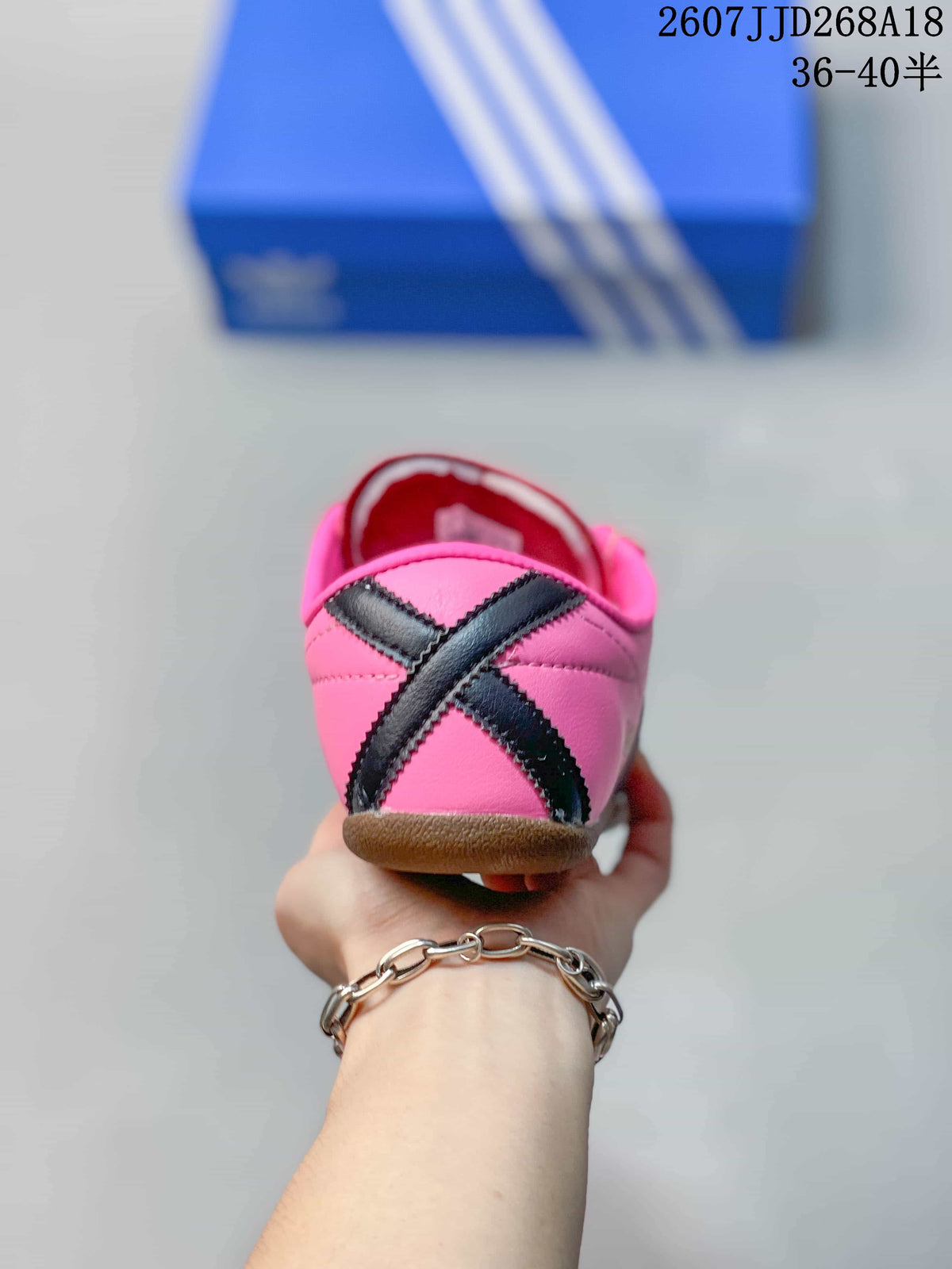 Rear view of the pink sneaker showing the black crossed heel detail and gum-colored outsole.