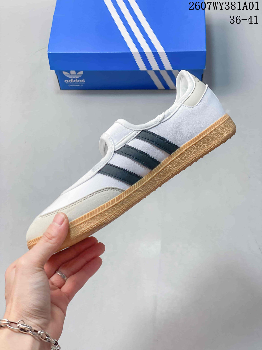 Side view of a white Samba Jane sneaker with grey stripes and a gum-colored sole