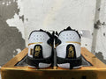 Rear view of white, black, and gold Nike GT Cut 3 basketball shoes