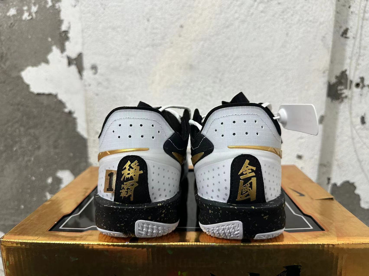 Rear view of white, black, and gold Nike GT Cut 3 basketball shoes