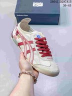 Angled side view showing the cream and red sneaker design with stitched detailing