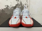 Front view of white and red Nike basketball sneakers with perforated uppers