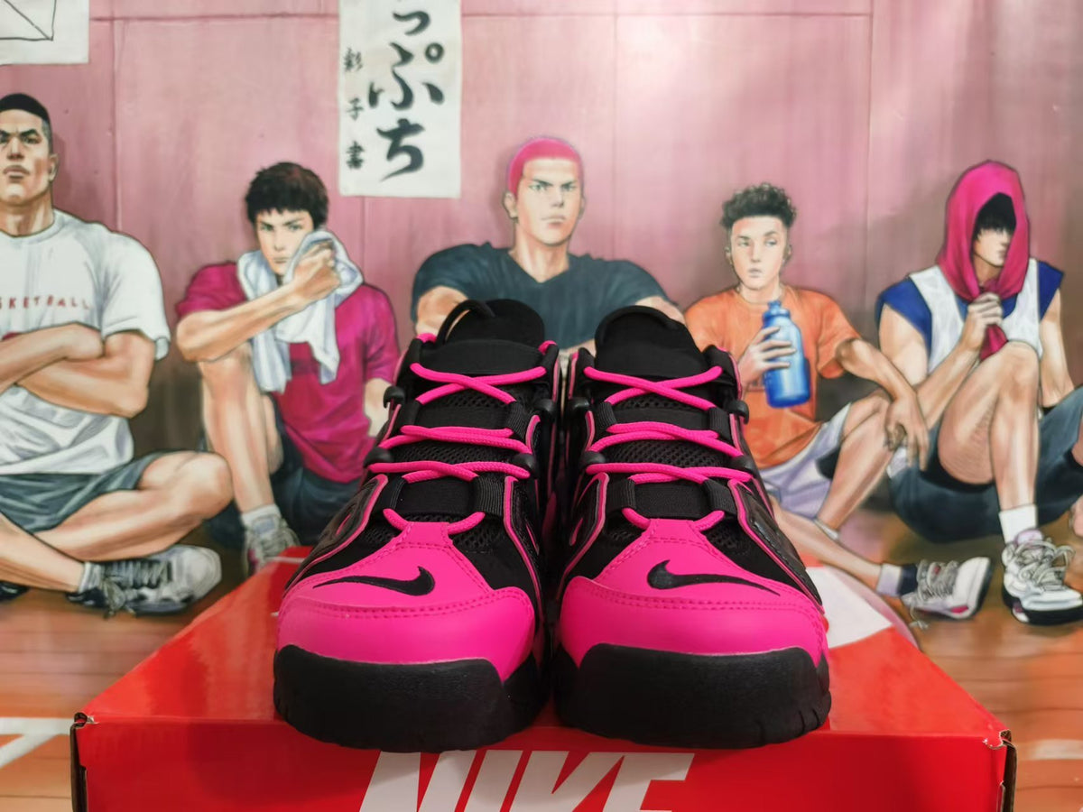 Front view of black and bright pink Nike sneakers with lace-up fastening
