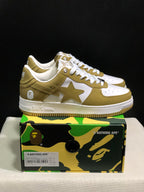 Side view of olive and white BAPE STA sneakers showing the star side panels, white midsoles, and olive outsole edges.