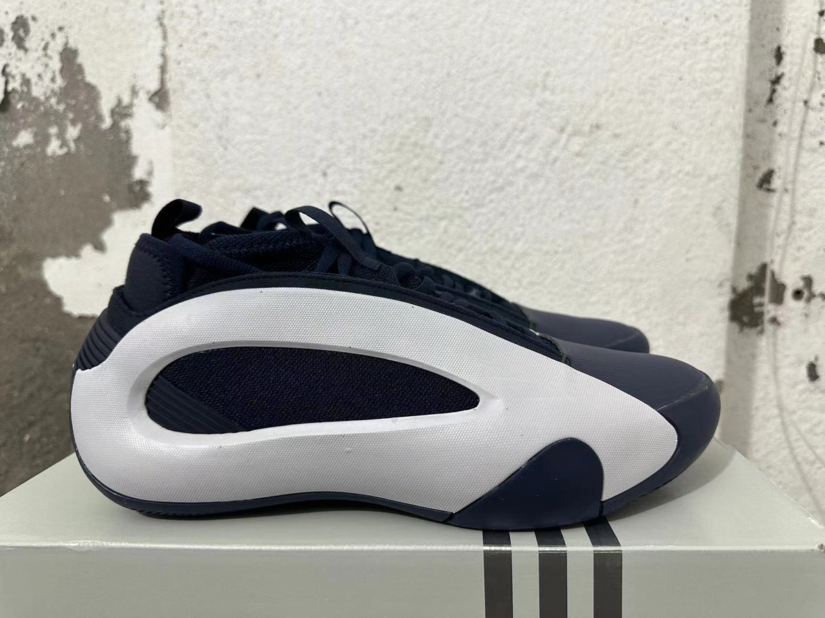 Side view of navy and white Adidas basketball shoes with sculpted white side panels.