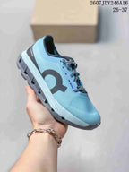 Light blue On Cloudstratus 3 kids running shoe with a dark side logo and contrasting outsole.