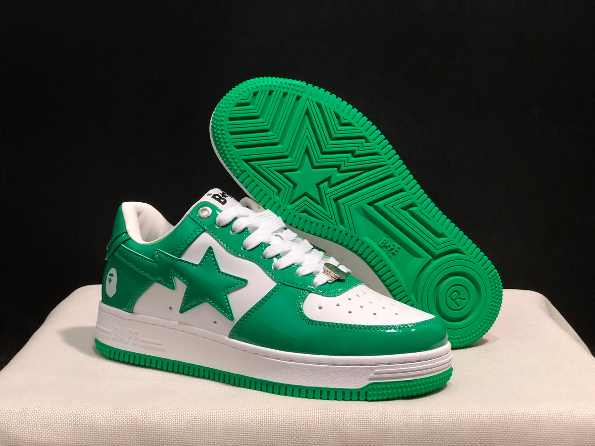 Angled view of the sneakers with one shoe lifted to show the green outsole and star-shaped tread pattern.