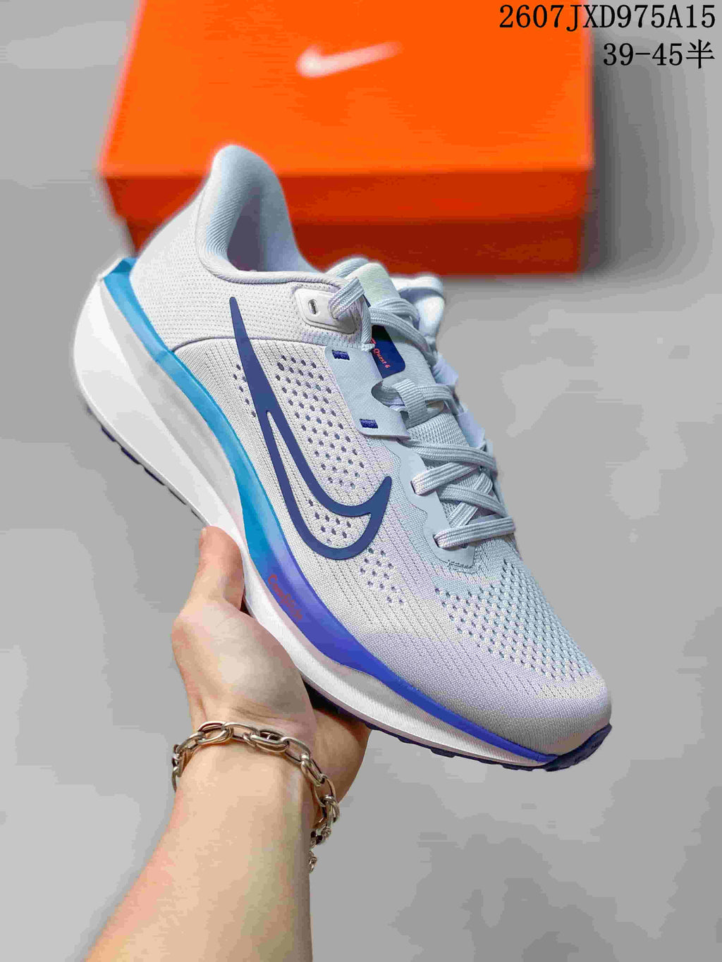 Angled view of a white Nike Quest 6 sneaker with blue side and heel accents.