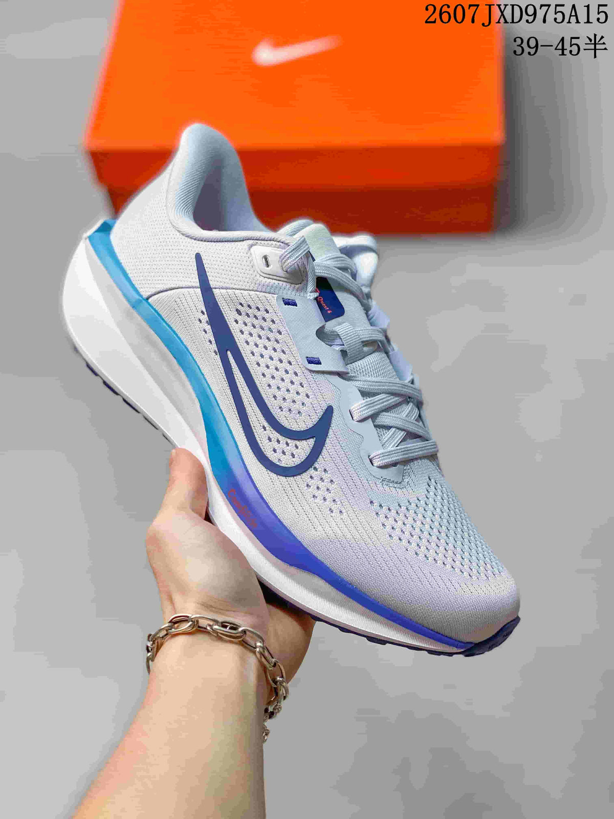 Angled view of a white Nike Quest 6 sneaker with blue side and heel accents.