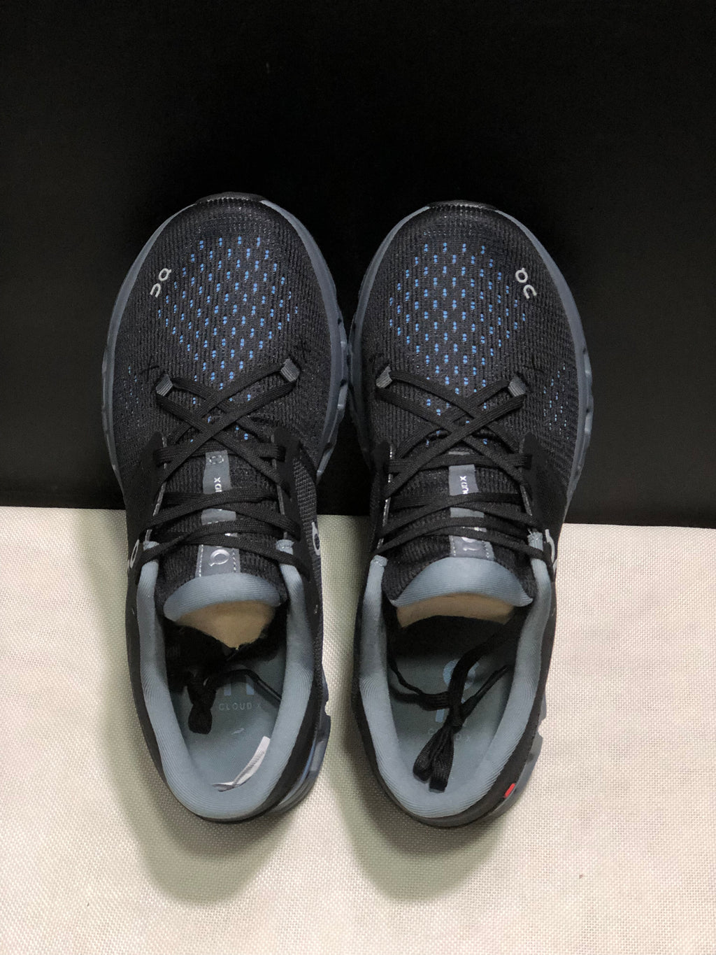 Top view showing the black textured uppers, blue detailing, laces, and gray collars.