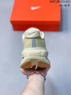 Rear view of the cream sneakers showing padded collars, heel details, and segmented outsole.