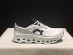 Side profile showing the white sneaker, large side branding, black collar, and layered sole.