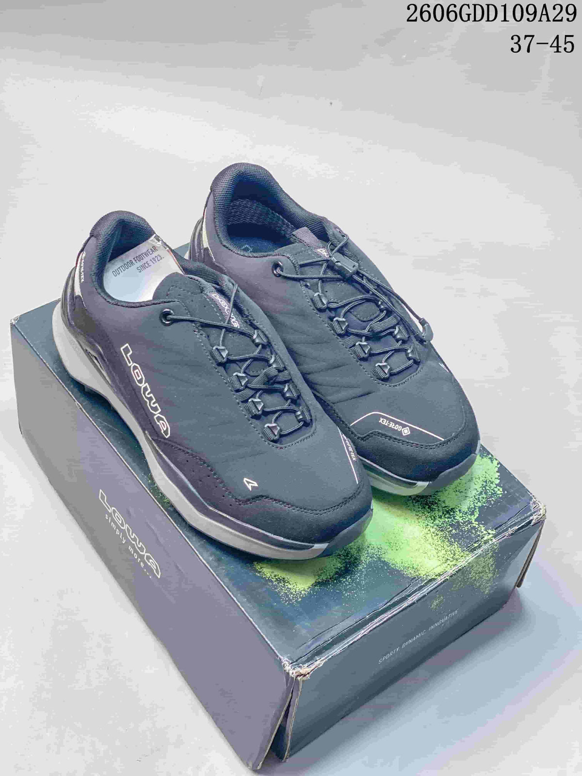 Pair of dark gray LOWA low-cut outdoor shoes on a branded box