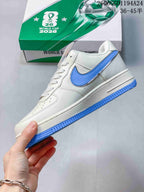 Side view of the white low-top sneaker with blue Swoosh and blue outsole.