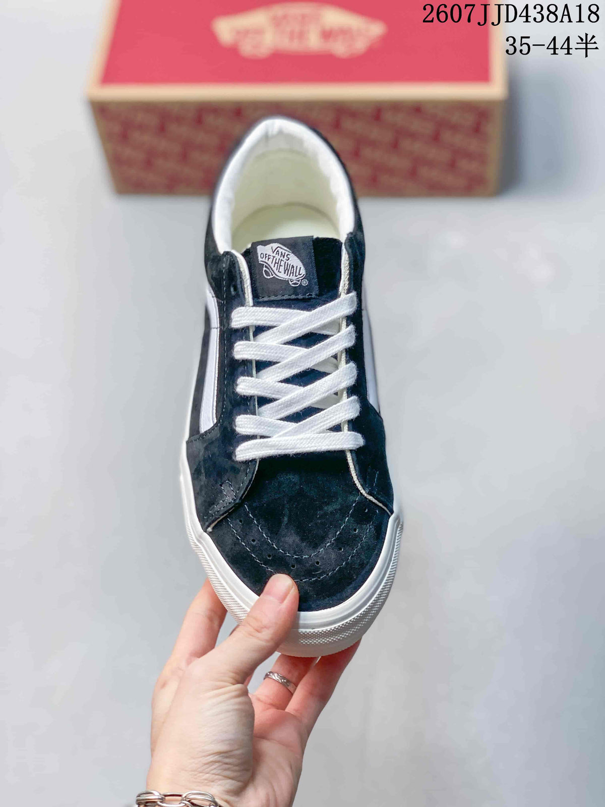 Top view of the black low-top sneaker showing white laces, stitched panels, and a Vans tongue label.