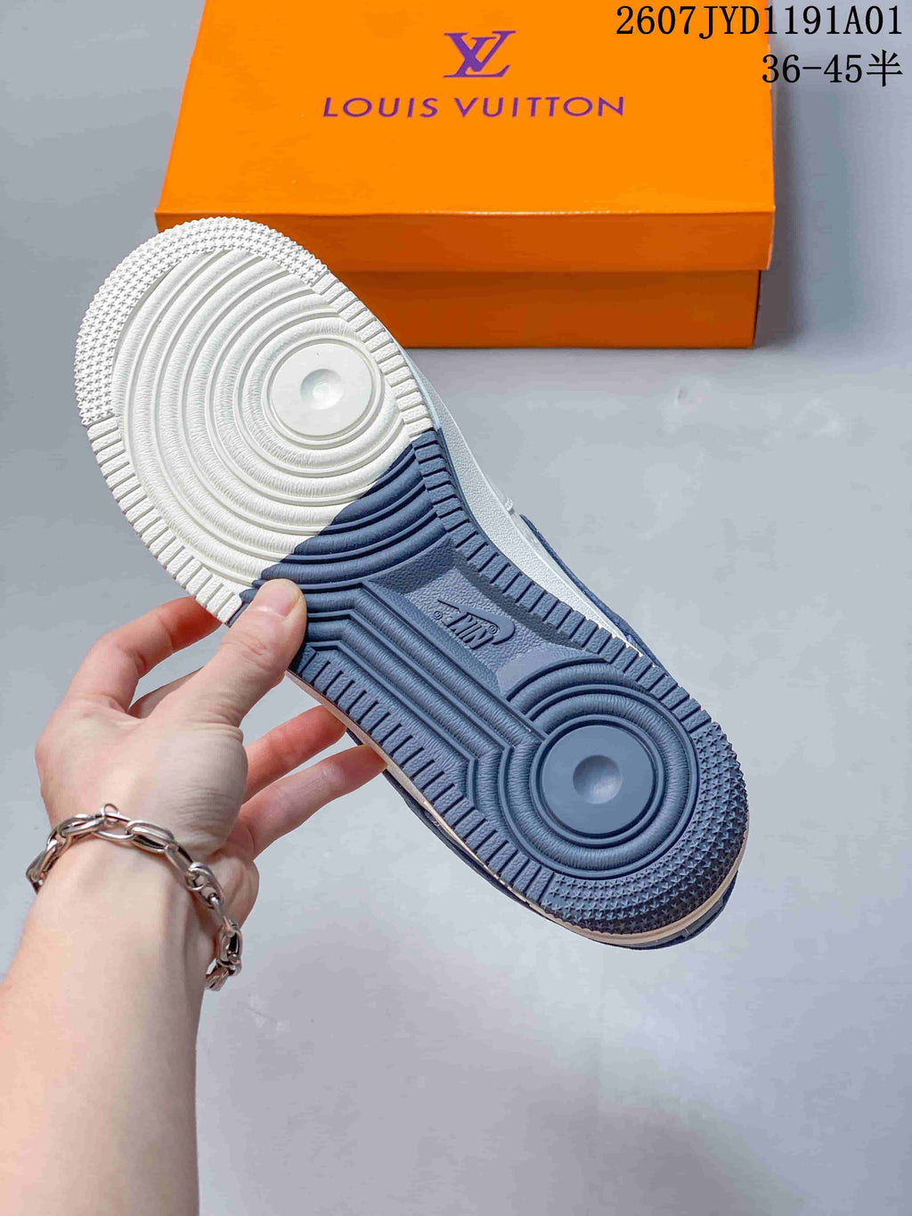 Close-up of the sneaker outsole showing white and navy sections and circular tread details.
