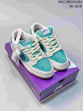 Pair of teal, white, and blue Nike SB Dunk Low Pro sneakers on a purple box, with spare white laces pictured.