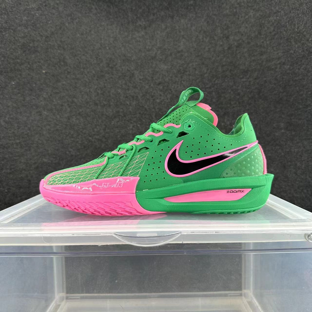 Green Nike low-top basketball sneaker with pink accents, a black-and-pink side logo, and visible Zoom Air branding