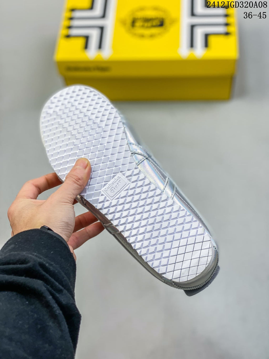Underside of the sneaker showing the white textured rubber outsole and branding detail.