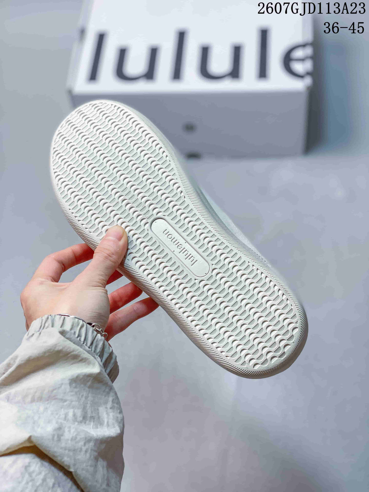 Close-up of the white sneaker outsole showing its repeating textured tread pattern and central lululemon branding.