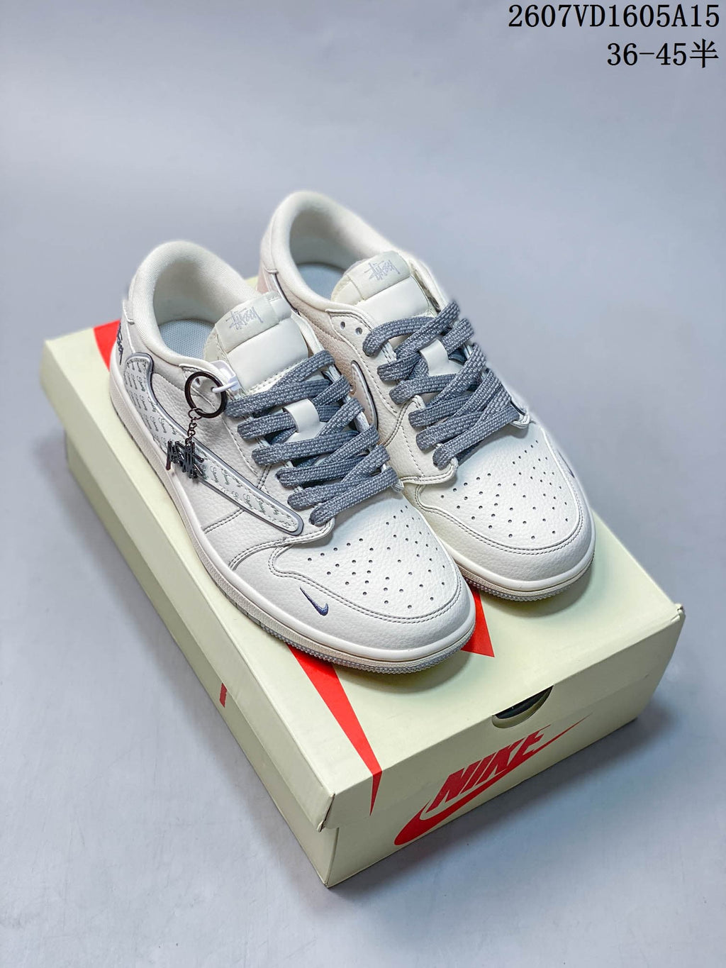 Pair of white and grey low-top sneakers shown from above on a Nike-branded box, with patterned side details.