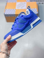 Side profile of a blue Louis Vuitton Trainer sneaker showing layered panels, mesh sections, and the contrasting midsole.
