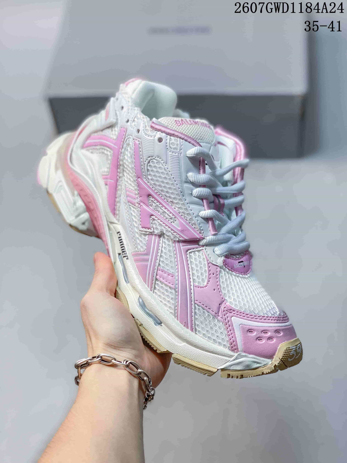 Angled side view highlighting the pink and white layered upper and patterned outsole.