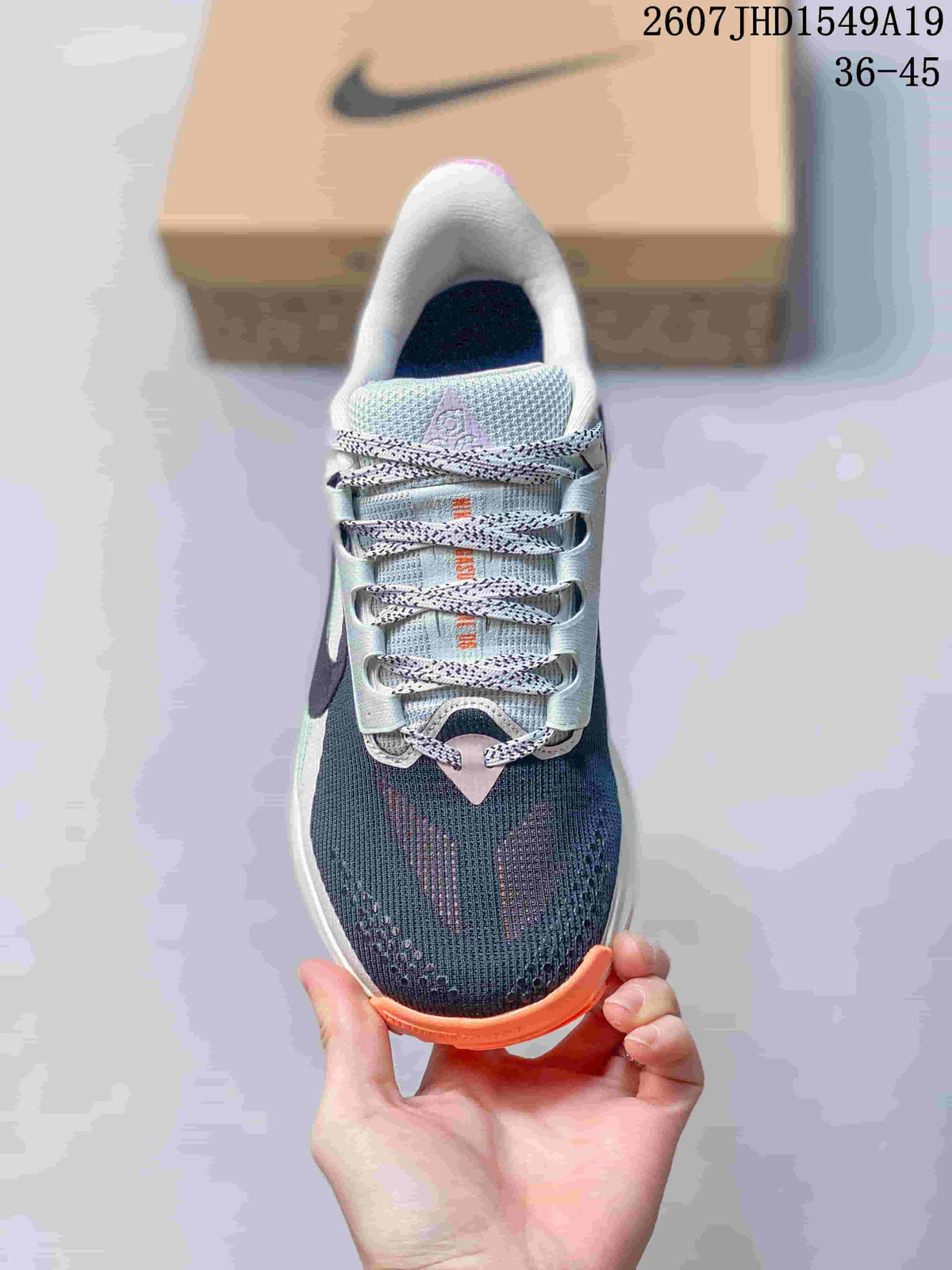 Top view showing the navy mesh toe, patterned laces, pale tongue and orange toe-edge accent.