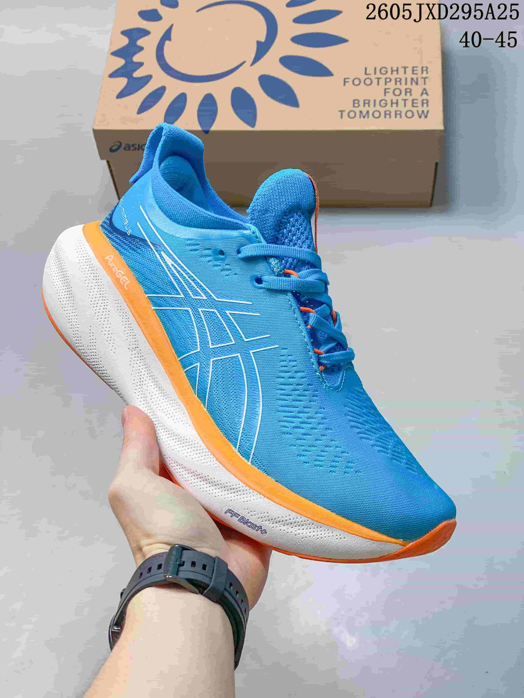 Close side view of the blue ASICS GEL-NIMBUS 27 with white midsole and orange trim