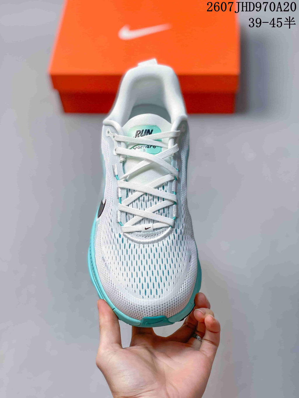 Top view of a white lace-up sneaker with turquoise detailing, perforated-looking upper, and black Swoosh branding.