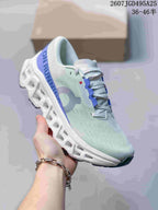 Angled side view showing On branding, blue heel detailing and the sculpted sole