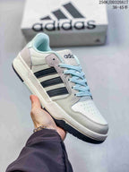 White adidas Entrap sneaker with black side stripes, light blue laces and a dark outsole.