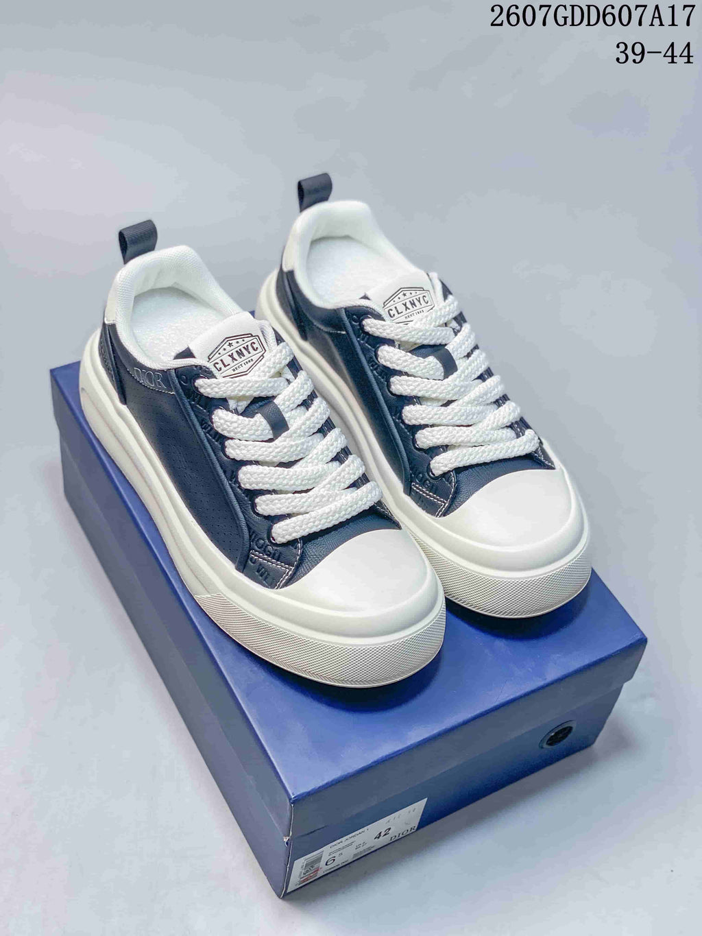 Pair of navy and white Dior sneakers displayed on a blue shoe box; image text shows style code 2607GDD607A17 and size range 39–44.