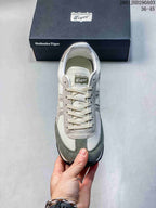 Top view of the sneaker showing cream laces, the branded tongue label, and gray-green toe overlays.