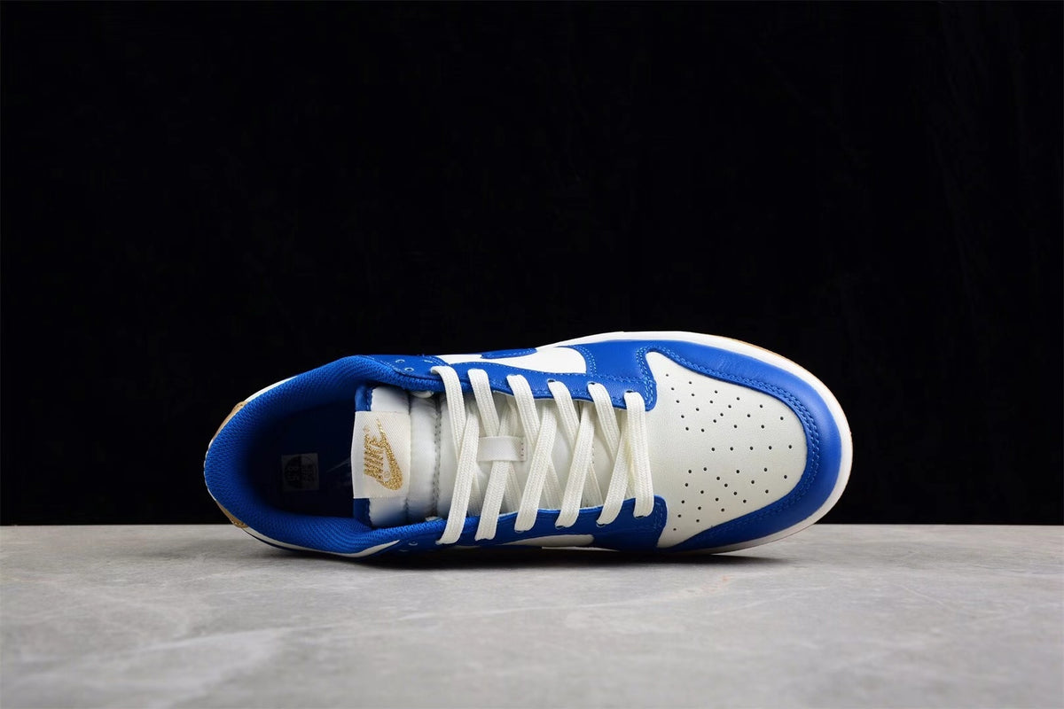 Top view of one sneaker showing the lacing system, blue padded collar, white toe box, and perforations.