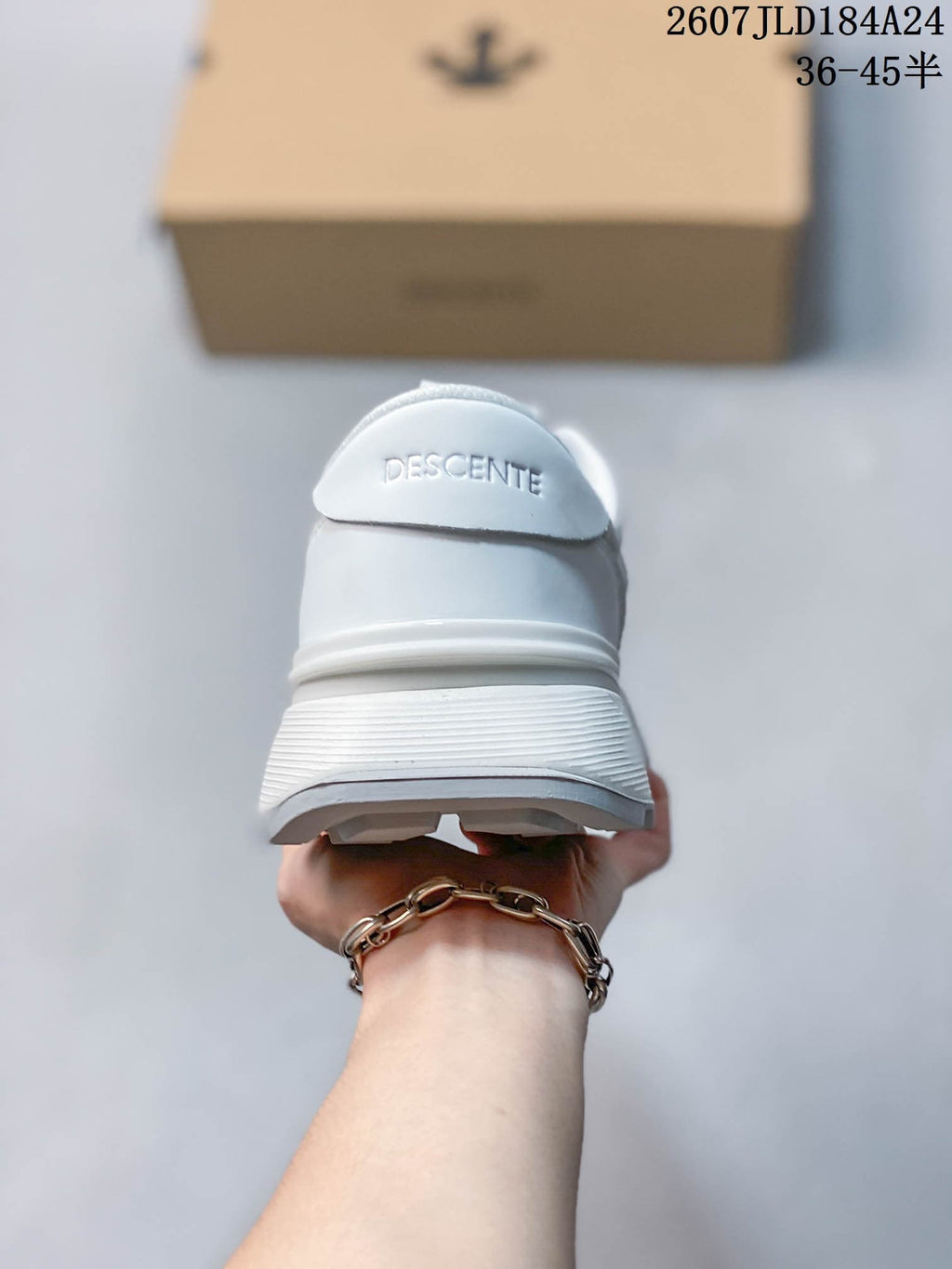Rear view of the white sneaker showing the padded heel area and Descente branding.