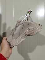 Angled rear view of the khaki Balenciaga sneaker showing layered panels, repeated branding, and the textured sole.