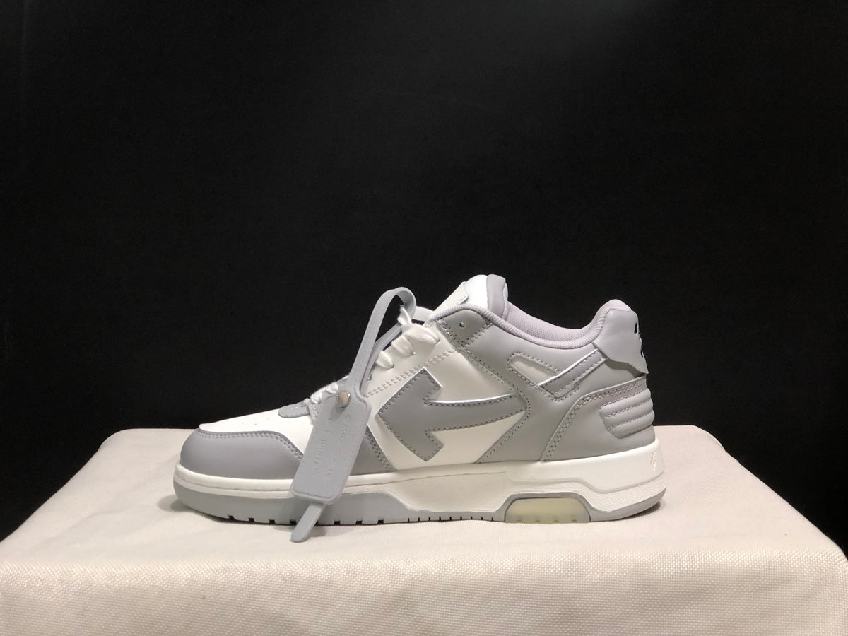Side view of one sneaker highlighting the layered upper construction, attached hangtag, and outsole.