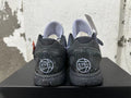 Rear view of purple and black Nike Kobe basketball shoes with speckled soles and EYBL graphics.