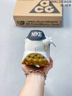 Rear view of a white Nike ACG sneaker showing the dark heel panel, padded collar, and gum-colored outsole.